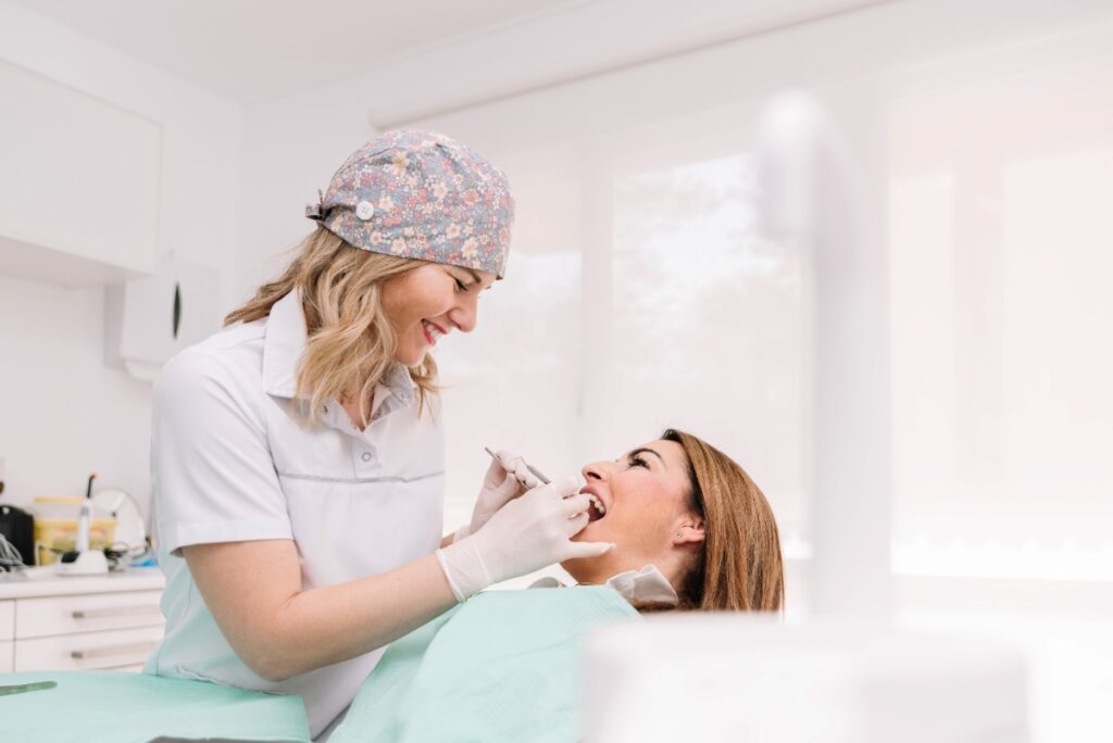 Une dentiste souriante qui soigne une patiente