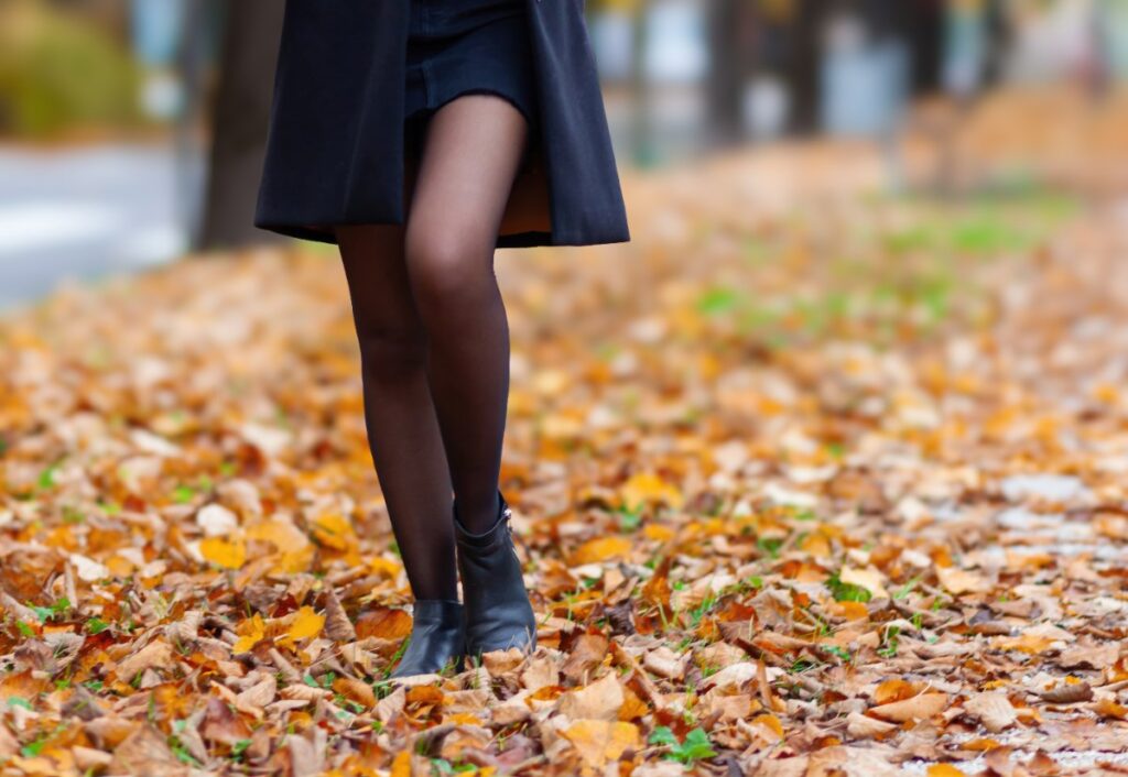 Une femme en robe bleu marine et collant noir