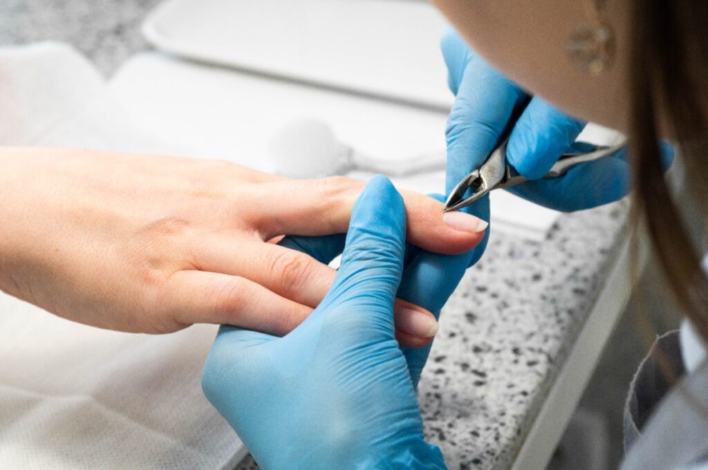 Une esthéticienne qui enlève des cuticules