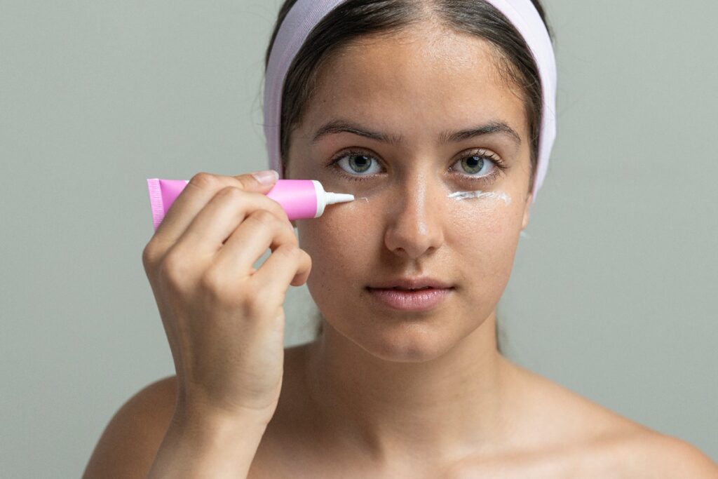Une femme appliquant de la crème hémorroïdes autour de ses yeux