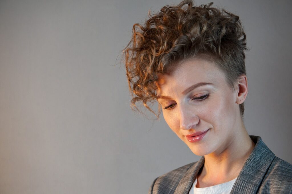 Une jeune femme ayant des cheveux bouclés et courts