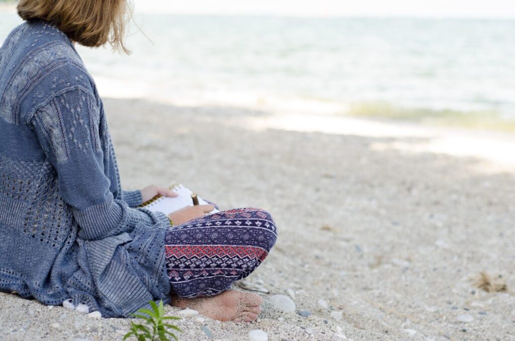Une jeune femme assise sur le sable à une plage