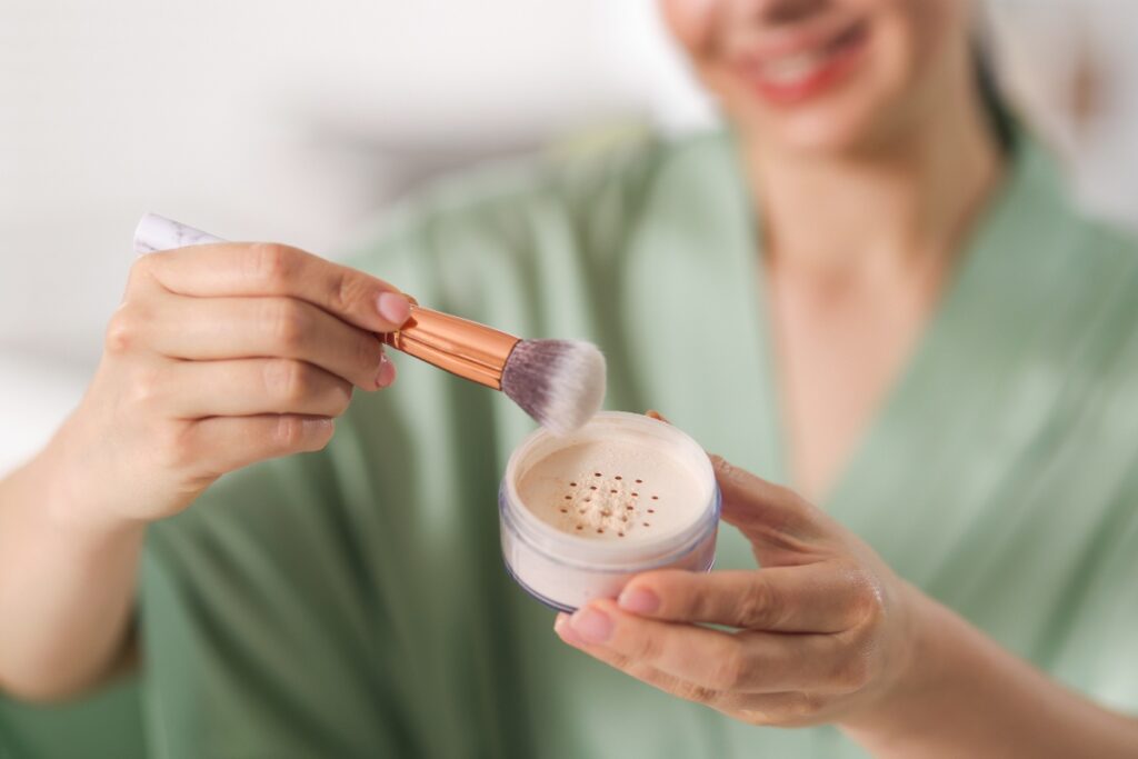 Une femme prenant du poudre cosmétique avec un pinceau