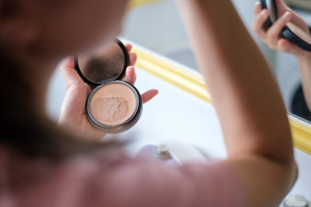 Une femme tenant du poudre cosmétique