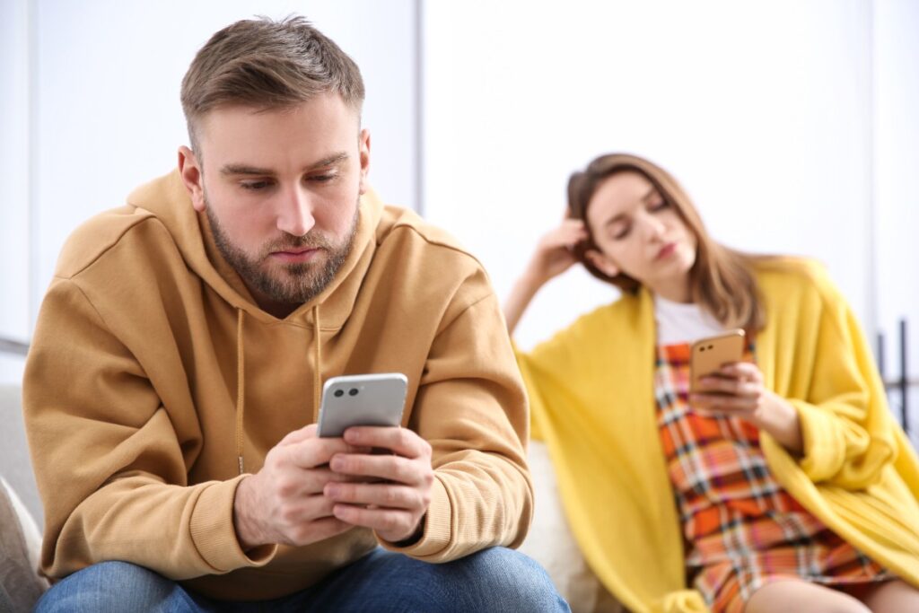 Un homme et une femme accrochés à leurs téléphones