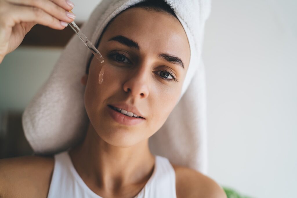Une femme appliquant du sérum sur le visage
