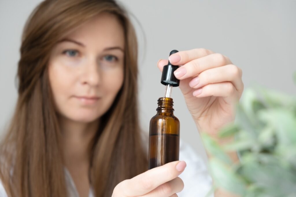 Une femme ouvrant un flacon de liquide 