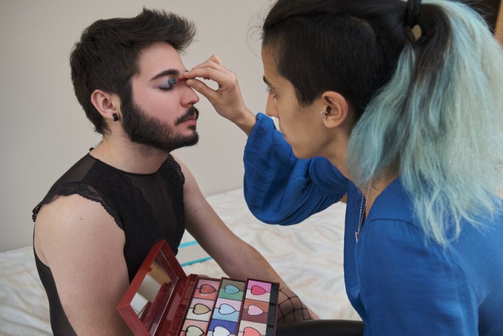 Une femme réalisant du maquillage pour un homme