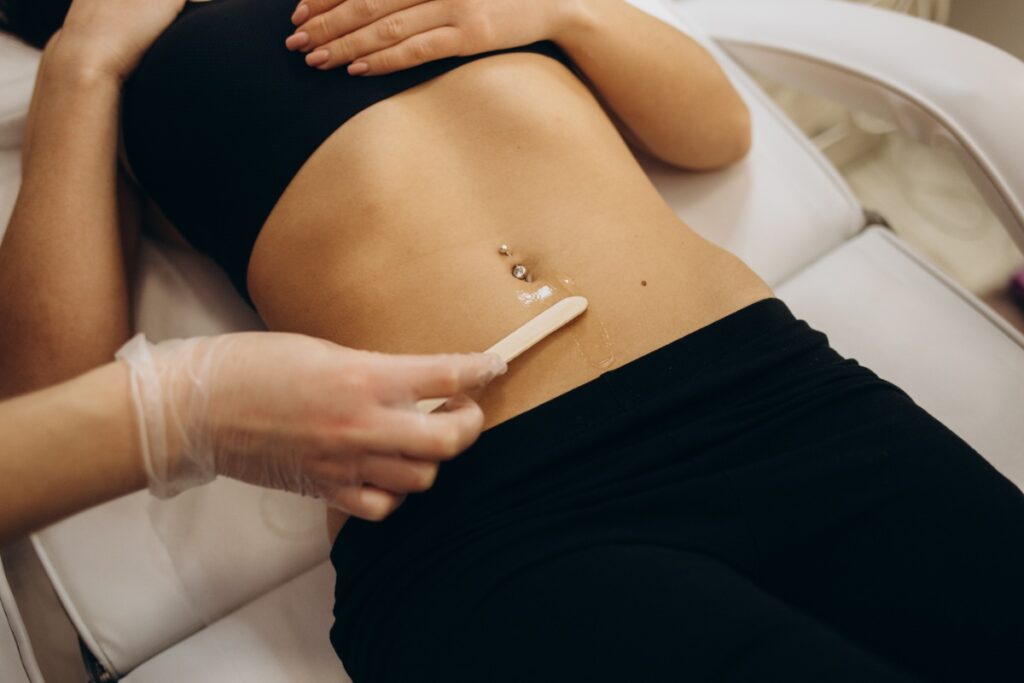 Une femme recevant du soin esthétique sur le ventre