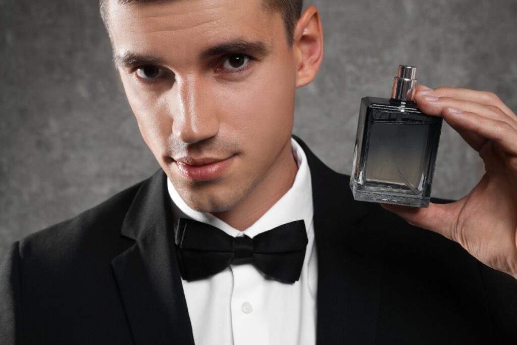 Un homme élégant qui tient un flacon de parfum
